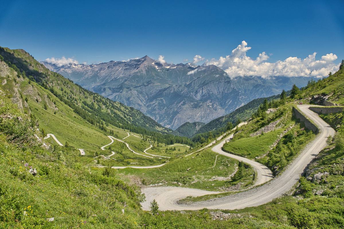 Kurvenreiche Schotterstrasse im Tal